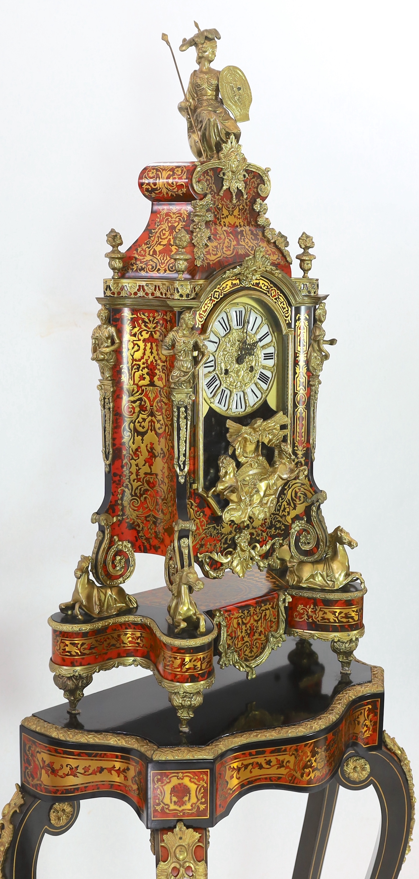 A Louis XV style brass mounted red boulle mantel clock on matching stand